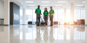 Janitorial team polishing a clean, shiny floor in a bright office lobby